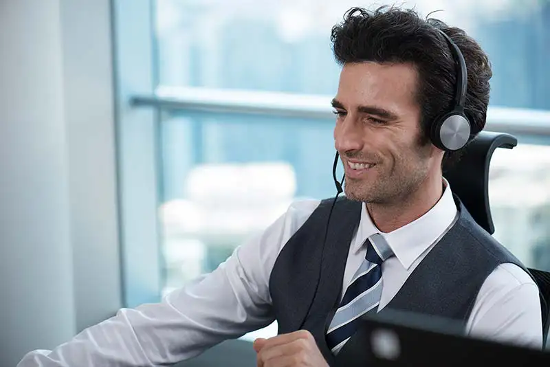 un homme souriant au support commercial avec casque